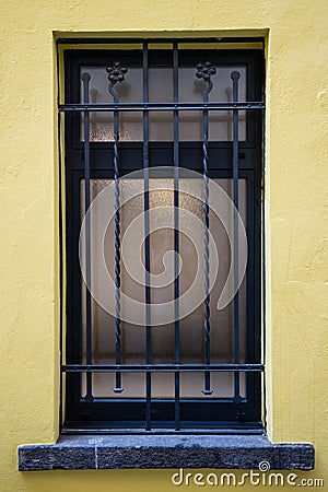 Window with black gate and yellow wall Stock Photo