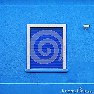 Window on blue facade with dark blue rolling shutters Stock Photo