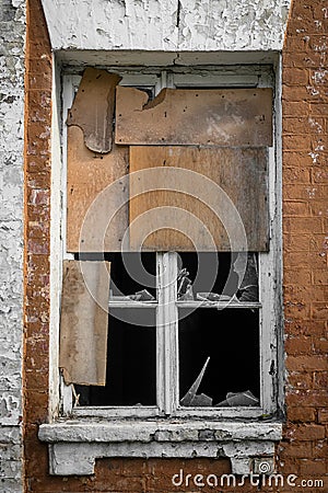 The window with broken glass of a destroyed building. Antique exterior, abandoned architecture. Ruin, damage. Broken window of old Stock Photo