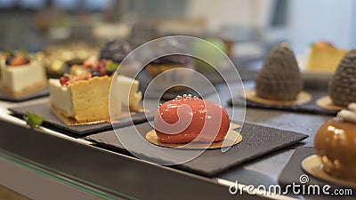 Window of cake shop with variety of cakes on display. Pastry shop with of muffins, eclaire, cakes with fruits, berries Stock Photo