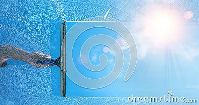 Window cleaner cleaning window with squeegee and wiper on a sunny day Stock Photo