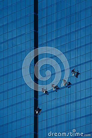 Window cleaner washes windows on a skyscraper Tower dangerous Editorial Stock Photo