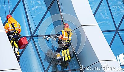 Window cleaner working on a glass facade modern skyscraper Editorial Stock Photo