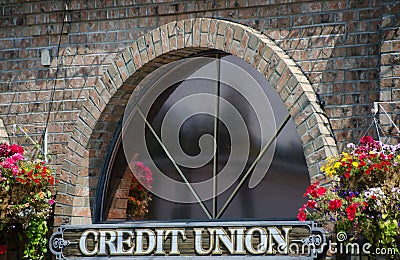 Window of a credit union surrounded by flower baskets Stock Photo