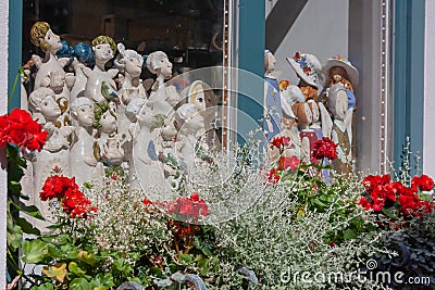 Window decoration with porcelain angels and flowering flower boxes Stock Photo