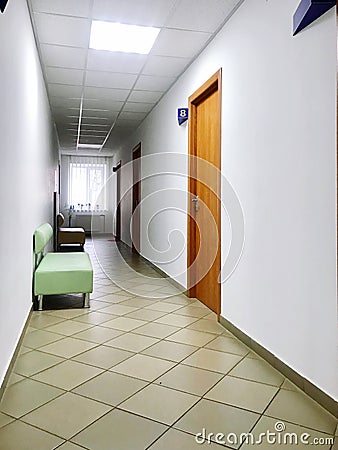 the window at the end of the corridor of the medical hospital center and the chairs from the door. Stock Photo