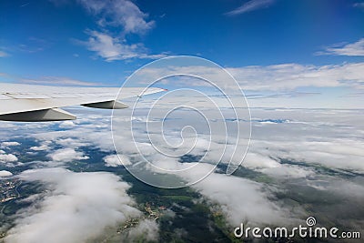 From window of flying plane airplane wing glides gracefully over sea of clouds Stock Photo