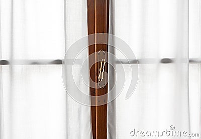 Window frame detail with vintage handle and white curtains Stock Photo