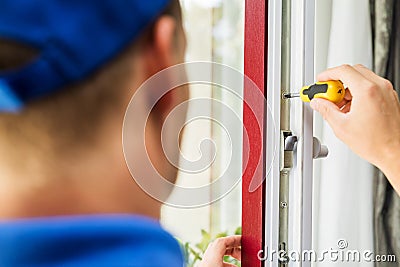 Window maintenance service - worker adjusting frame screws Stock Photo