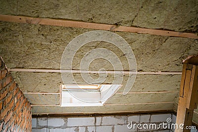 Window mounted in a pitched roof insulated with mineral wool Stock Photo