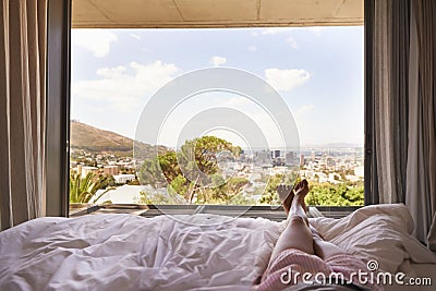 Window view, bedroom, relax and legs on holiday, morning relaxation and wake up. Apartment, stress relief and the feet Stock Photo