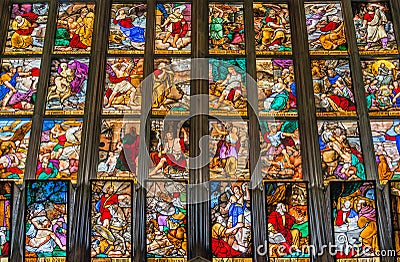 Window view with colorful glass depicting biblical scenes at magnificent Cathedral of Milano, Milan, Italy Editorial Stock Photo