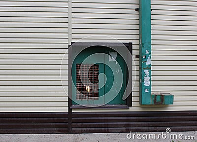 Window in the wall with a lamp behind bars Stock Photo