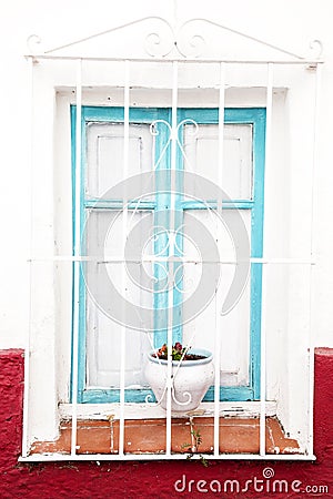 Window with white bars and pots with geraniums Stock Photo