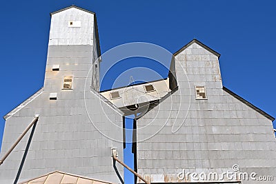 Windowed walkway at the top of two grain elevators Stock Photo