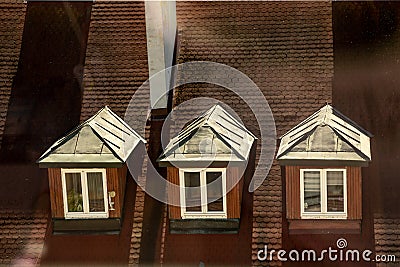 Windows of attic roof - a classic architectural design of old town with roof tiles Stock Photo