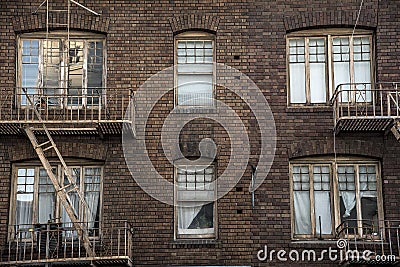 Windows and fire escapes tenement brick apartment building Stock Photo