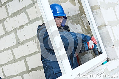 Windows installation. construction workers installing frame into aperture Stock Photo