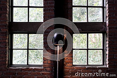 Windows of loft house with lamp on the brick wall. Stock Photo