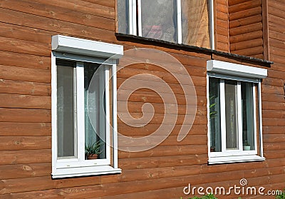 Windows with rolling shutter on the wooden house facade exterior Stock Photo