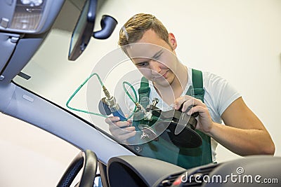 Windscreen repair by glazier in garage after stone-chipping damage Stock Photo