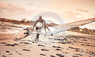 Windsurfer with board on Beach Seaside back view Sea Windsurfing Sport Stock Photo