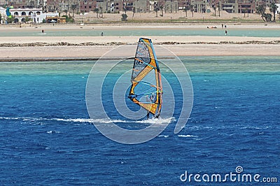 The windsurfer on the board under sail moves at a speed along the surface of the sea, Editorial Stock Photo