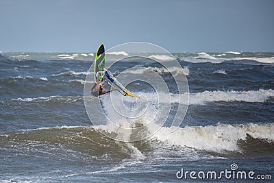 Windsurfer Jumps out of the Water: Stunting on Waves Stock Photo