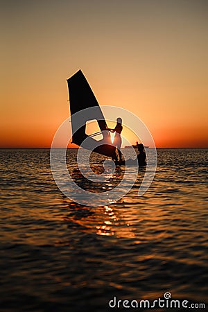 Windsurfer learning silhouette against sun Stock Photo