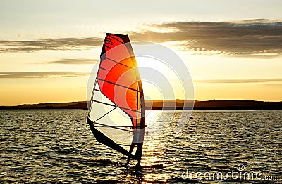 Windsurfer silhouette against a sunset background Stock Photo