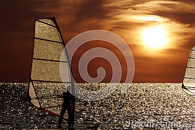 Windsurfer silhouette against a sunset background Stock Photo