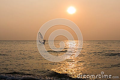 Windsurfer silhouette in front of sunset background Stock Photo