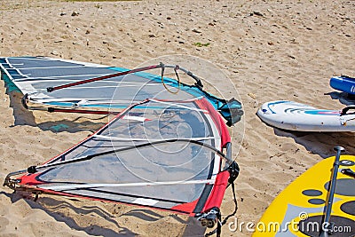 Windsurfing board with sail lying on the sand Stock Photo