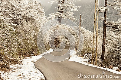 Windy snowy foggy slippery muddy flat step himalayan mountain road in winter. Leh Manali Highway, Jammu and Kashmir, India, Asia Stock Photo