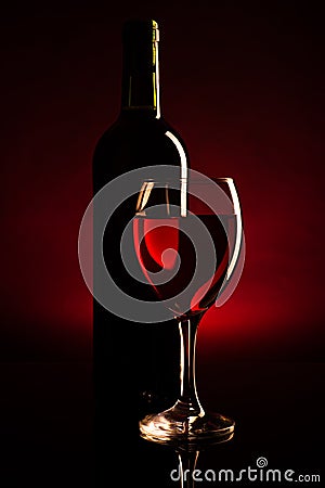 Wine bottle and glass silhouette over dark red Stock Photo
