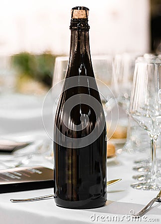 Wine champagne cider dark glass bottle blanck space in fancy table set in restaurant event celebration Stock Photo