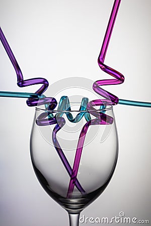 Wine glass and colourful straws. Stock Photo