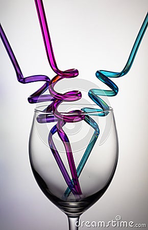 Wine glass and colourful straws. Stock Photo