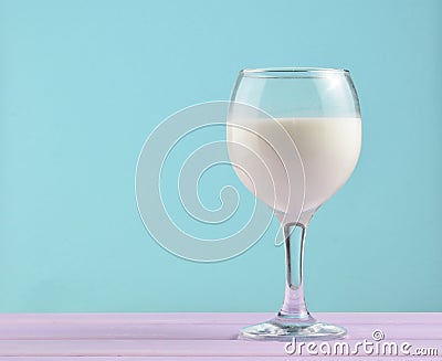 Wine glass of natural milk on a pastel background, nostalgia, minimalism trend, copy space. Stock Photo