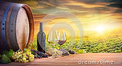 Wine Glasses And Bottle With Barrel In Vineyard Stock Photo