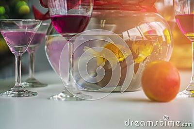 Wine glasses and cocktails and spirits and apples, and goldfish jar, Put on a wooden table at a Christmas party Stock Photo