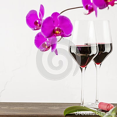 Wine glasses with natural red wine. on wooden table with orchids Stock Photo