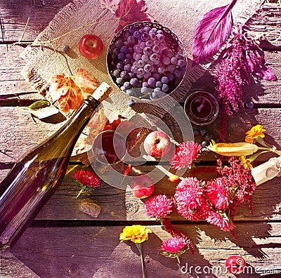 Wine, grapes and flowers on grungy wooden table. Stock Photo