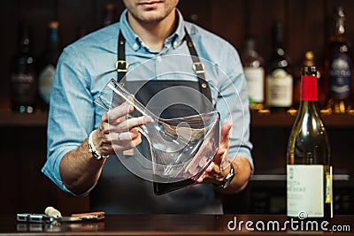 Wineglass at bar counter at background of sommelier with decanter with wine Stock Photo