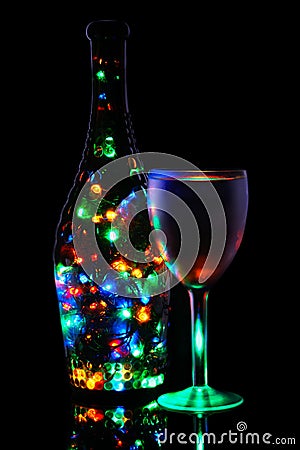 A wineglass and a bottle of lighted garland Stock Photo