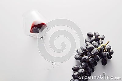 Wineglass with red wine, bunch of dark-colored grape. Stock Photo