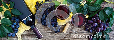 Wineglasses with red wine, bottle, corkscrew, blue grapes, leaves on a wooden table. Wine background with copy space. Top view, Stock Photo