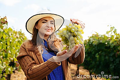 winemaker smilling adult woman with hat holding a bunch of white grape Stock Photo