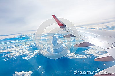 Wing of an airplane flying above the clouds view Stock Photo