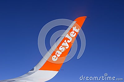 The wing and winglets of an Airbus A320 commercial airliner with a company logo while in flight Editorial Stock Photo